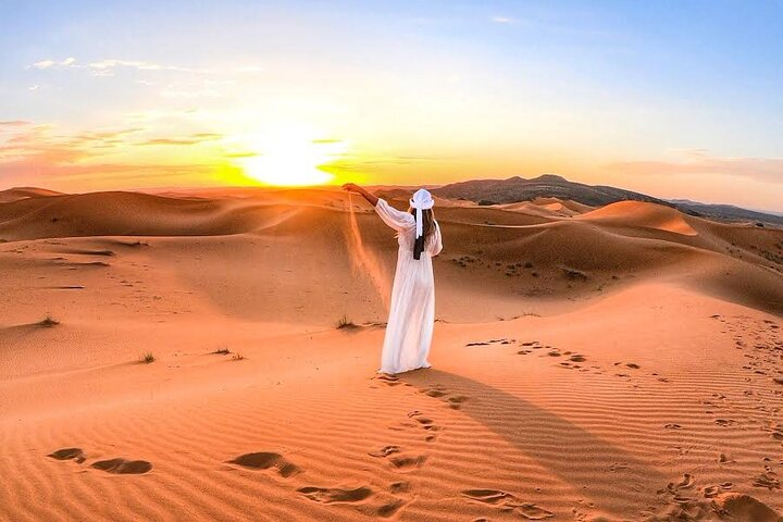 Experience the serene beauty of the desert at sunrise where golden sands stretch endlessly and the tranquil surroundings invite exploration and reflection in Dubai's vast wilderness.